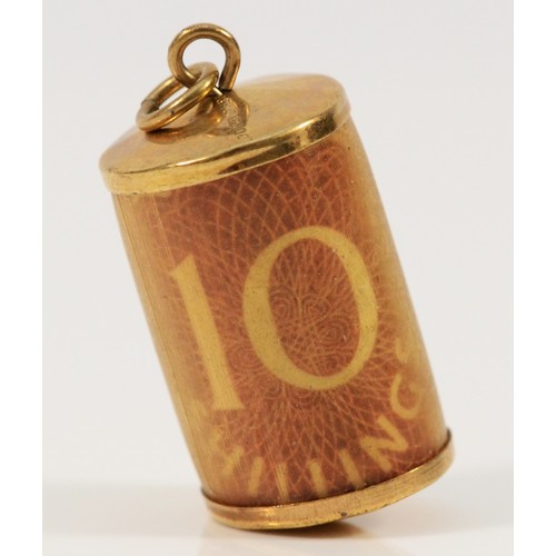 584 - A 9ct gold charm with 10 Shillings, 2.6g