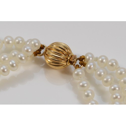 588 - A 9ct gold clasp cultured pearl three row bracelet, 19cm, 11.5g