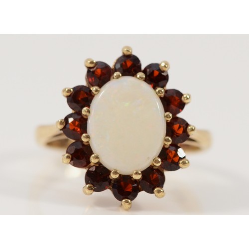 638 - A 9ct gold opal and garnet dress ring, 10mm x 7mm opal, L 1/2, 3.5g