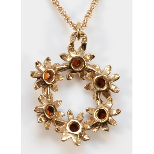 666 - A 9ct gold garnet floral wreath shaped pendant with chain, 17mm diameter, 3.6g