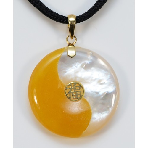 674 - A 14k gold yellow jade and mother of pearl yin yang pendant with cord chain, 25mm diameter, 1g