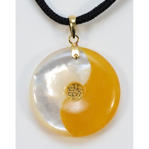 674 - A 14k gold yellow jade and mother of pearl yin yang pendant with cord chain, 25mm diameter, 1g