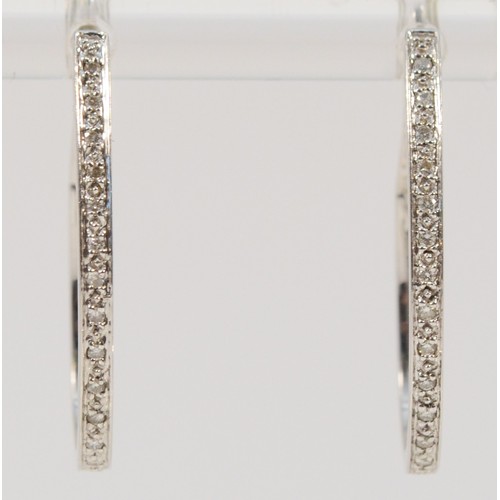 692 - A pair of 9ct white gold diamond hoop earrings, stated 0.15ct diamond weight, 25mm total drop, 3.3g