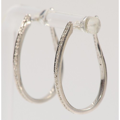 692 - A pair of 9ct white gold diamond hoop earrings, stated 0.15ct diamond weight, 25mm total drop, 3.3g