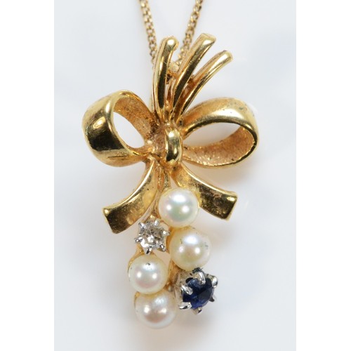 704 - A 9ct gold diamond, cultured pearl and sapphire bow shaped pendant with chain, 20mm total length, 1.... 