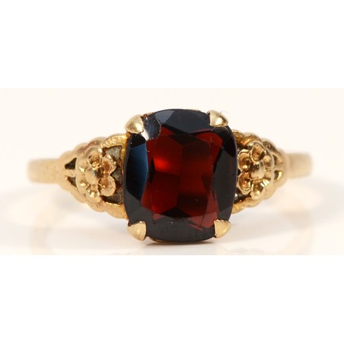 714 - A 9ct gold vintage garnet dress ring with floral patterned shoulders, R, 2.6g