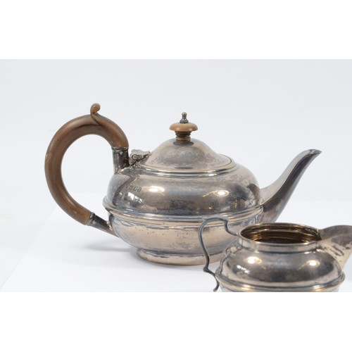 4 - A silver three piece bachelors tea service, London 1922, of compressed form, comprising tea pot, sug... 