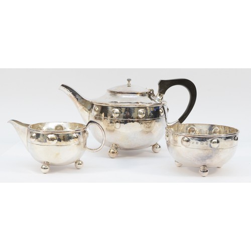 18 - An Arts & Crafts three piece silver tea service, by A.E. Jones, Birmingham 1911/12, of spot hammered... 