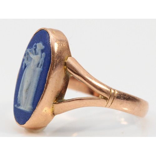 74 - A 9ct rose gold Wedgwood blue jasperware ring depicting a woman playing a harp, split shoulders, Che... 