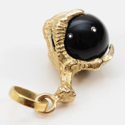 75 - A 9ct gold claw pendant holding an onyx ball, 10mm diameter onyx, 20mm total claw length, 2.7g