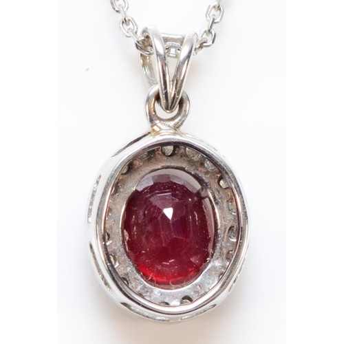 97 - An 18ct white gold diamond and enhanced ruby pendant with a chain, a 7mm x 5mm enhanced ruby surroun... 