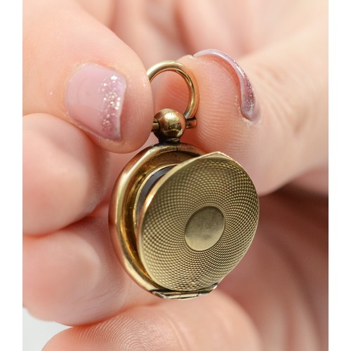 140 - A 9ct gold Victorian locket in the form of a pocket watch, glass in one side, 20mm diameter, 4.9g