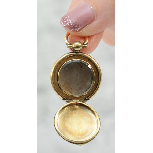 140 - A 9ct gold Victorian locket in the form of a pocket watch, glass in one side, 20mm diameter, 4.9g