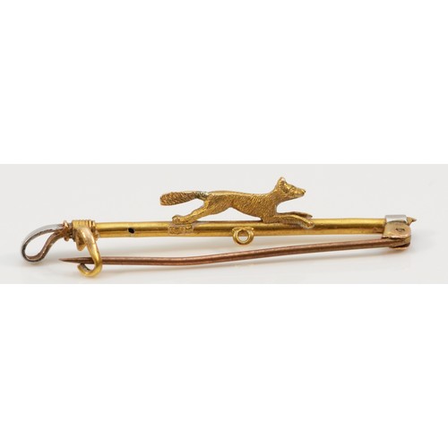 143 - A 15ct gold antique fox hunting brooch, a small fox running on top of a riding crop, the crop handle... 