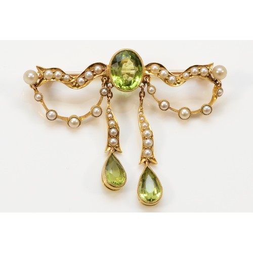 165 - A tested 15ct gold Edwardian peridot and seed pearl brooch with a 9ct pin, milgrain detailing surrou... 