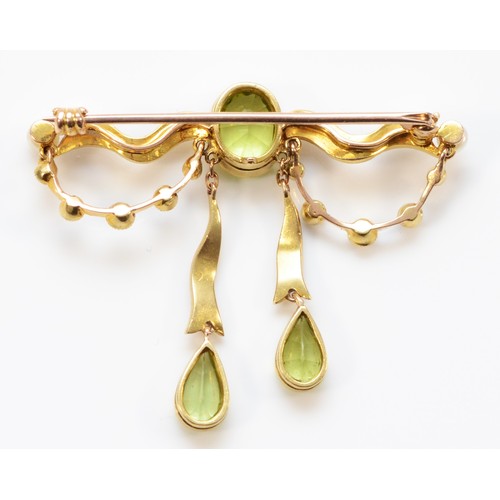 165 - A tested 15ct gold Edwardian peridot and seed pearl brooch with a 9ct pin, milgrain detailing surrou... 