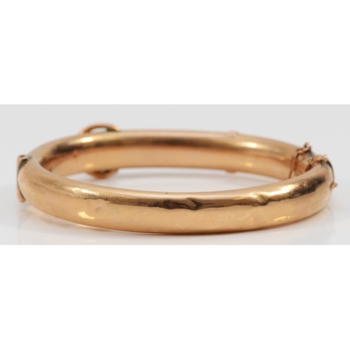 211 - An Edwardian 9ct rose gold hinged buckle bangle, Chester 1907, the front with engraved scroll decora... 