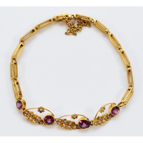 214 - An Edwardian unmarked 15ct gold, almandine garnet and half pearl bracelet, 16.5cm, 7.3gm.