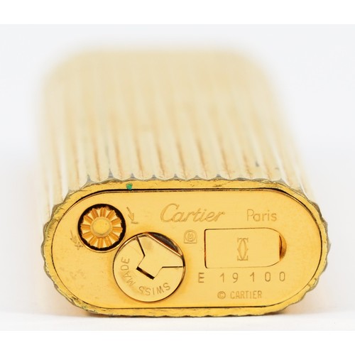 261 - Cartier, Paris, a gold plated oval rollagas ribbed lighter, signed, numbered E 19100, non Cartier po... 