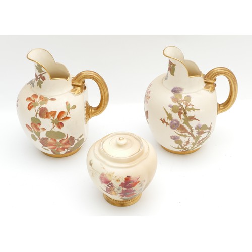 287 - A pair of Royal Worcester pitchers, together with a lidded jar, decorated in blush ivory with a flor... 