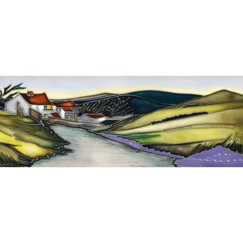 335 - A Moorcroft plaque, depicting house nestled amongst green hills, with a river in the foreground, des... 