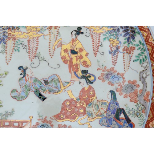 492 - A Japanese Meiji period Imari wall mounted charger, decorated with four ladies in a garden, four cha... 