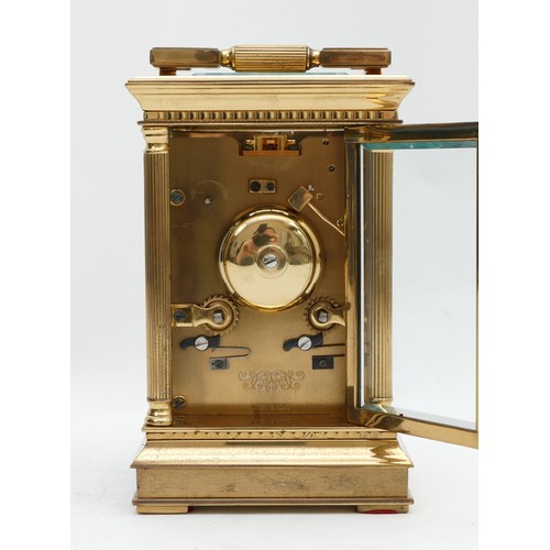 517 - A 20th century brass striking carriage clock, white enamel dial with Roman numerals and floral engra... 