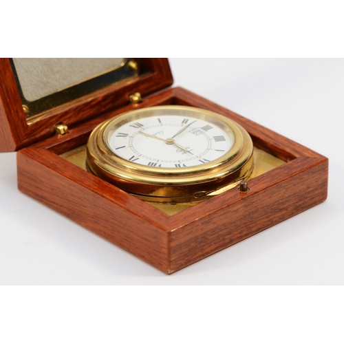 531 - Asprey, a gilt brass circular travel alarm clock with date aperture, synthetic sapphire crown, hours... 