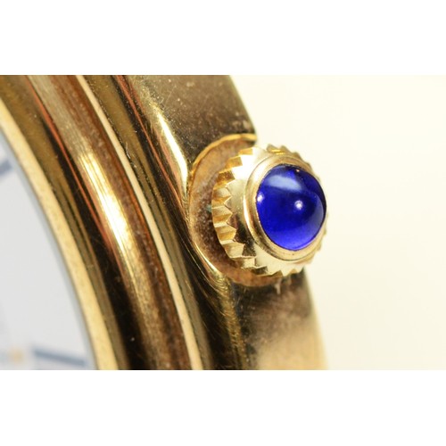 531 - Asprey, a gilt brass circular travel alarm clock with date aperture, synthetic sapphire crown, hours... 