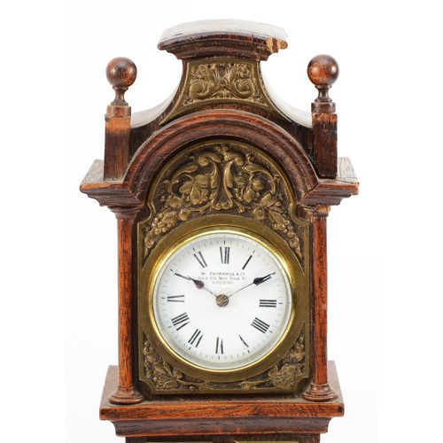 551 - W. Thornhill & Co., an Edwardian oak and brass miniature longcase clock, white enamel dial with Roma... 