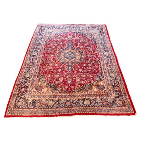 575 - A late 19th century Persian hand woven carpet, having a terracotta ground with central blue medallio... 