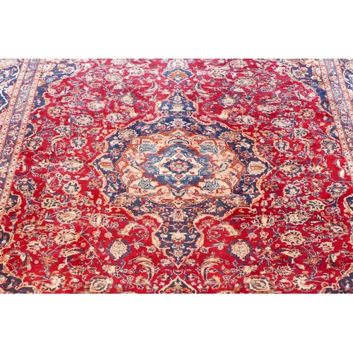 575 - A late 19th century Persian hand woven carpet, having a terracotta ground with central blue medallio... 