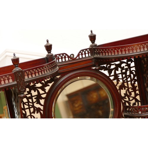 581 - An Edwardian mahogany wall-mounted over mantle display shelf, having central circular mirror, flanke... 