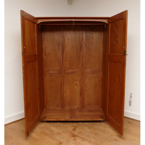 582 - A 1960s Ercol light elm 'Windsor' double door compactum wardrobe, enclosed by two fielded doors, the... 