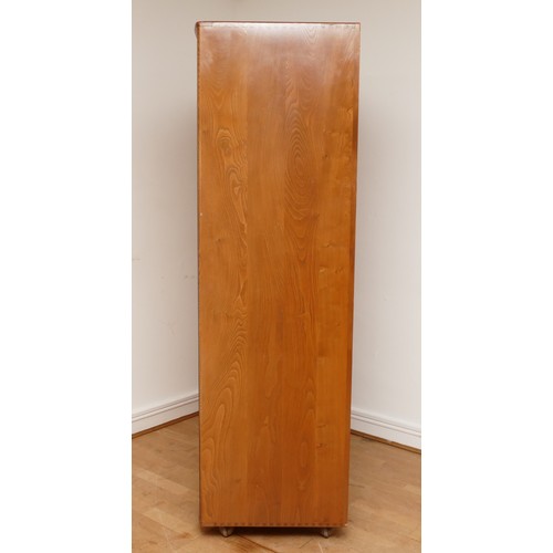 582 - A 1960s Ercol light elm 'Windsor' double door compactum wardrobe, enclosed by two fielded doors, the... 