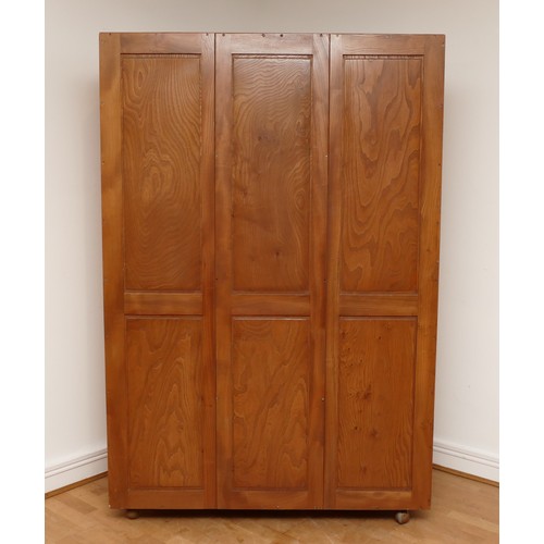 582 - A 1960s Ercol light elm 'Windsor' double door compactum wardrobe, enclosed by two fielded doors, the... 