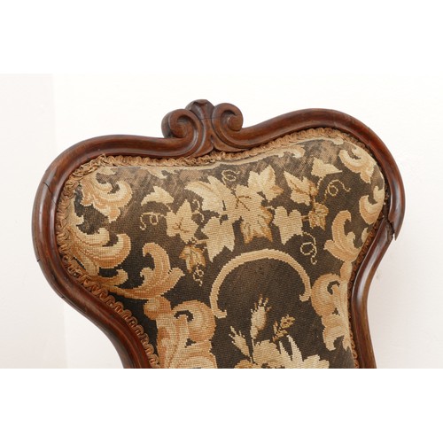 586 - A Victorian carved rosewood prieux deux chair, floral scroll back on cabriole legs, upholstered in f... 