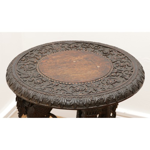 588 - A late 19th century Anglo Indian carved padouk centre table, the circular top with vine decoration, ... 