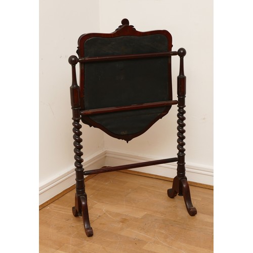 589 - A Victorian mahogany fire screen, scrolled foliage carved pediment, shield frame enclosing figural n... 