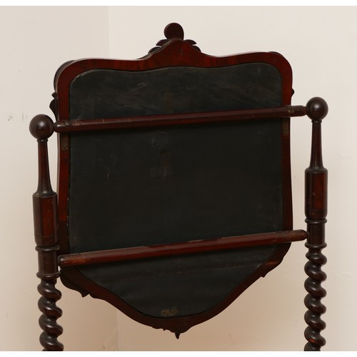 589 - A Victorian mahogany fire screen, scrolled foliage carved pediment, shield frame enclosing figural n... 