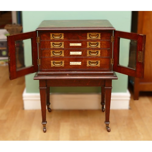 596 - A late 19th century oak canteen side cabinet, the two glazed doors opening to a bank of four drawers... 