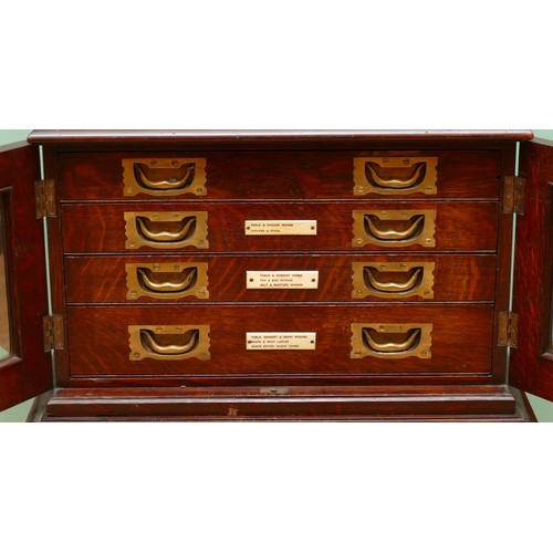 596 - A late 19th century oak canteen side cabinet, the two glazed doors opening to a bank of four drawers... 