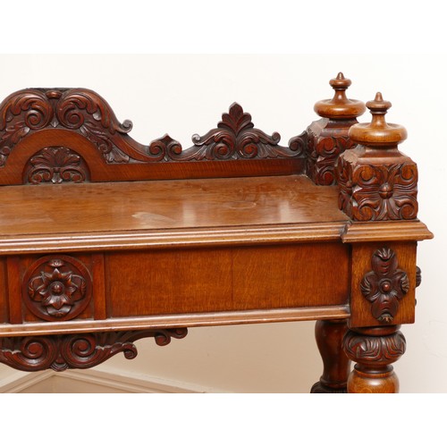 599 - An Edwardian carved oak entrance hall table, the rectangular top having galleried upstand carved fol... 