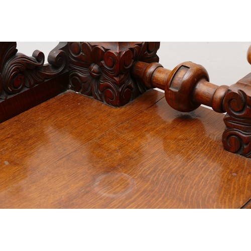 599 - An Edwardian carved oak entrance hall table, the rectangular top having galleried upstand carved fol... 