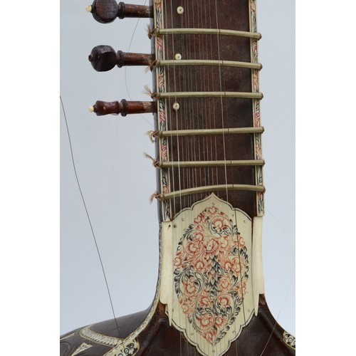 90 - An Indian Sitar, featuring five playing strings and eleven sympathetic strings and decorated with bo... 