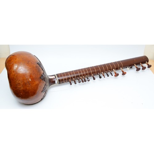 90 - An Indian Sitar, featuring five playing strings and eleven sympathetic strings and decorated with bo... 