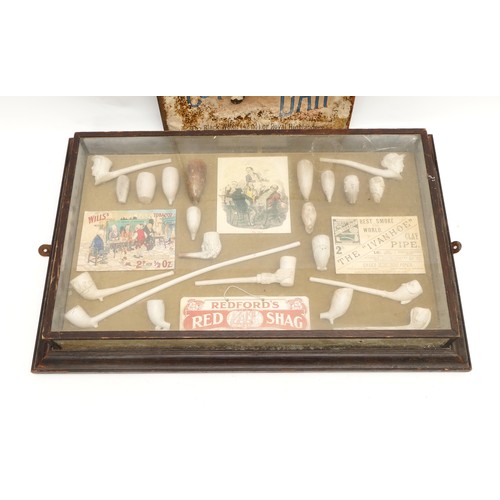 214 - Twenty-one white-clay moulded smoking pipes, mounted and displayed in a glass case, together with an... 