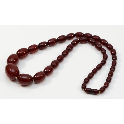 13 - A Bakelite cherry amber graduated bead necklace, composed of forty-two beads, the largest bead 3cm w... 