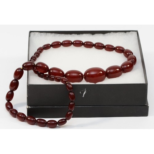 13 - A Bakelite cherry amber graduated bead necklace, composed of forty-two beads, the largest bead 3cm w... 