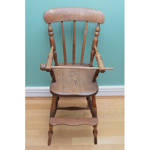 26 - An Edwardian elm children's high chair, with a three-post spindle and stretcher, H-88cm.